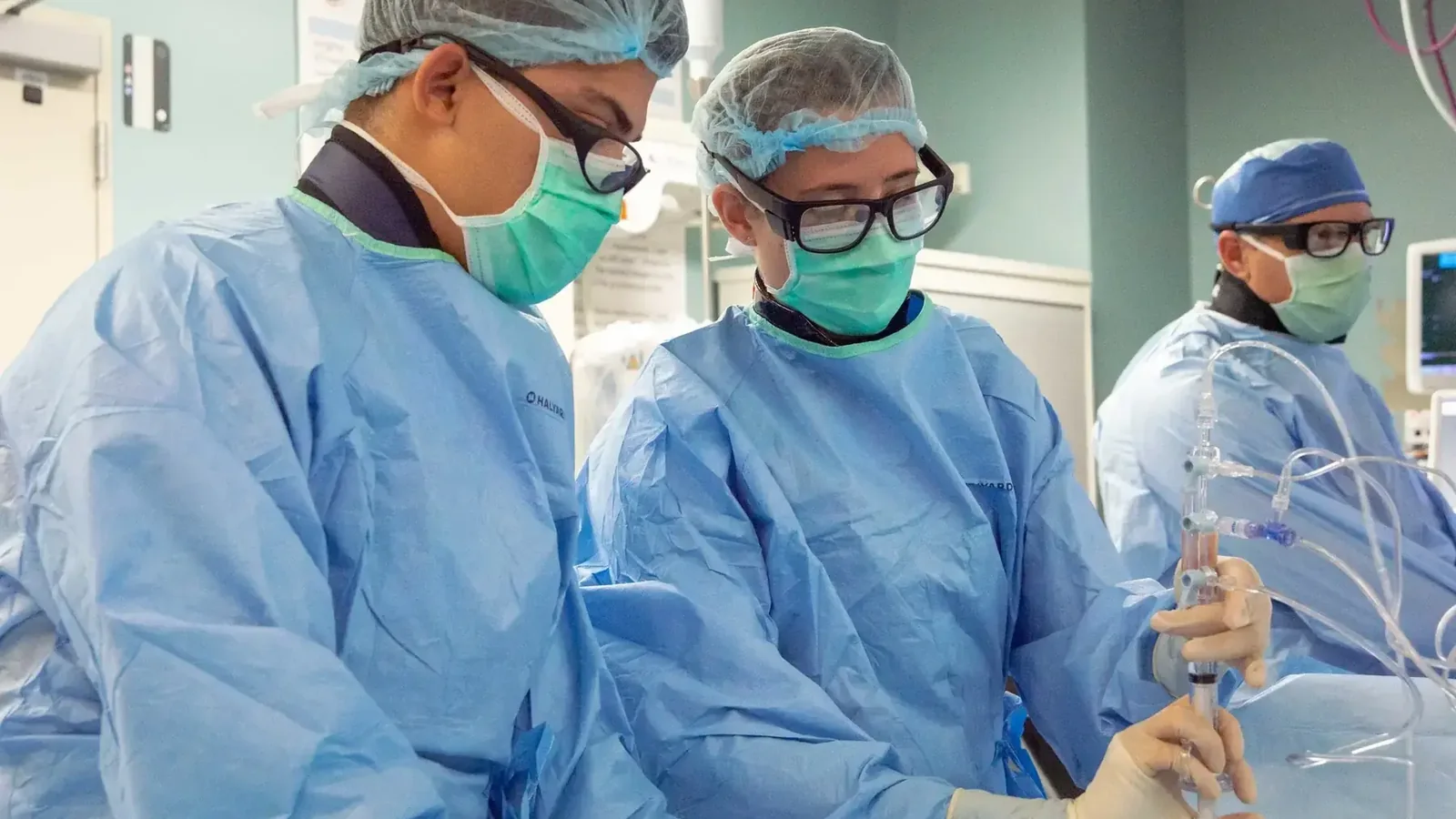 Clinical interventional team working with catheterization equipment in a controlled environment